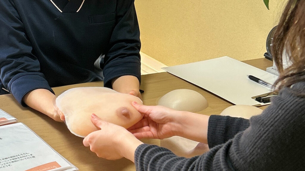 人工乳房エピテーゼのカウンセリング風景 スタッフとお客様が乳房エピテーゼを触って説明している写真