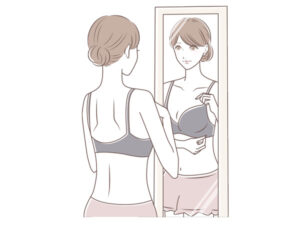 鏡の前でブラジャーを着用する女性